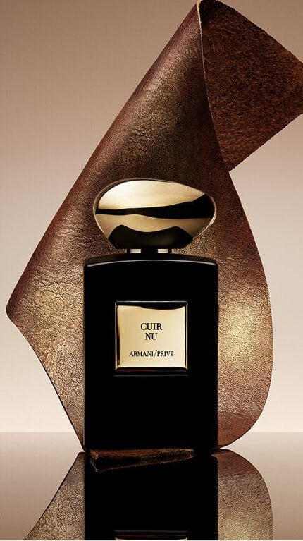 Bottle of Armani/Prive Cuir Nu agaisnt a warm leather background and ambery ingredient.
