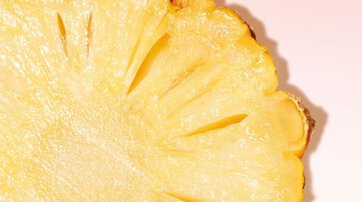 Slice of pineapple on pink background