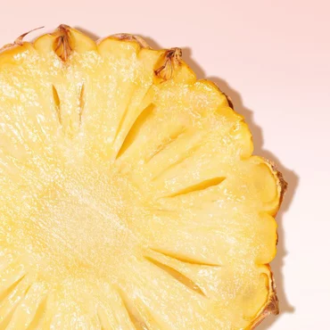 Slice of pineapple on pink background