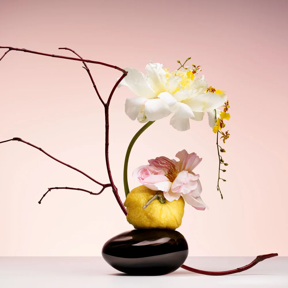 ARMANI/PRIVE PIVOINE SUZHOU: artistic ikebana arrangement with peony and lemon, evoking elevated craftsmanship and freshness.