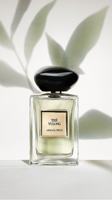Bottle of Armani/Prive The Yulong against a light green background leaf shadows.