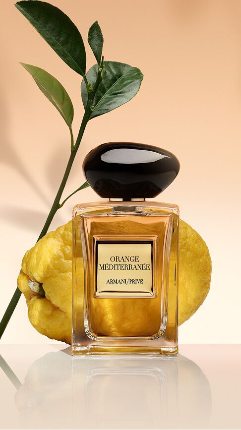Bottle of Armani/Prive Orange Mediterranee against a warm background featuring citrus ingredients.