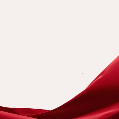 A luxurious red silk fabric flutters against a tan background