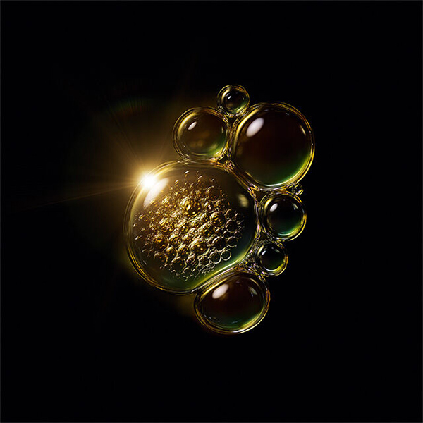 gold and green shimmering serum bubble droplets with light shining through on black background